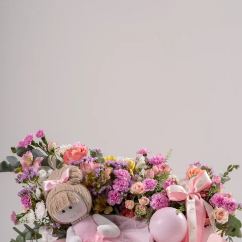 Box Flor de amor - Box maternidade feminina com arranjo floral em tons rosa e lilás, balões delicados e bonec